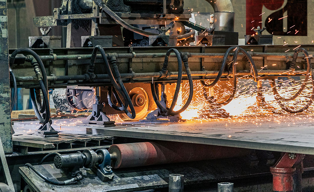 Metal processing machine cutting and welding steel plates with sparks